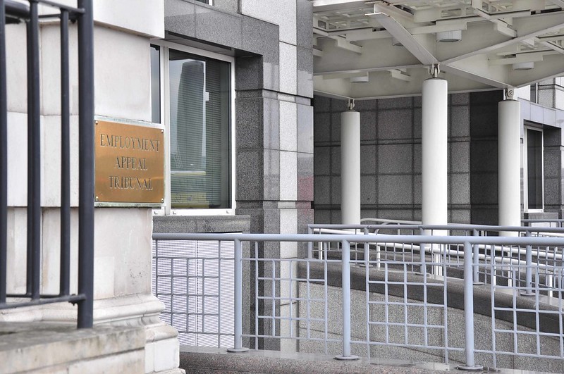 Image shows the front of the Employment Appeals Tribunal, a grey frontage with a bronze sign that reads 'Employment Appeal Tribunal'.